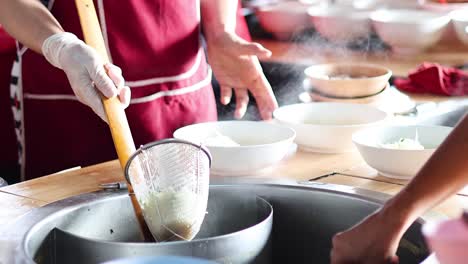 sequential noodle preparation in a group cooking setting.