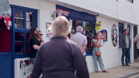 people walking past a bustling cafe