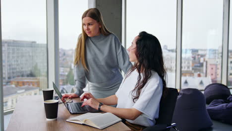 writing letters to the clients. two female colleagues communicate and make up an official message to the partners.