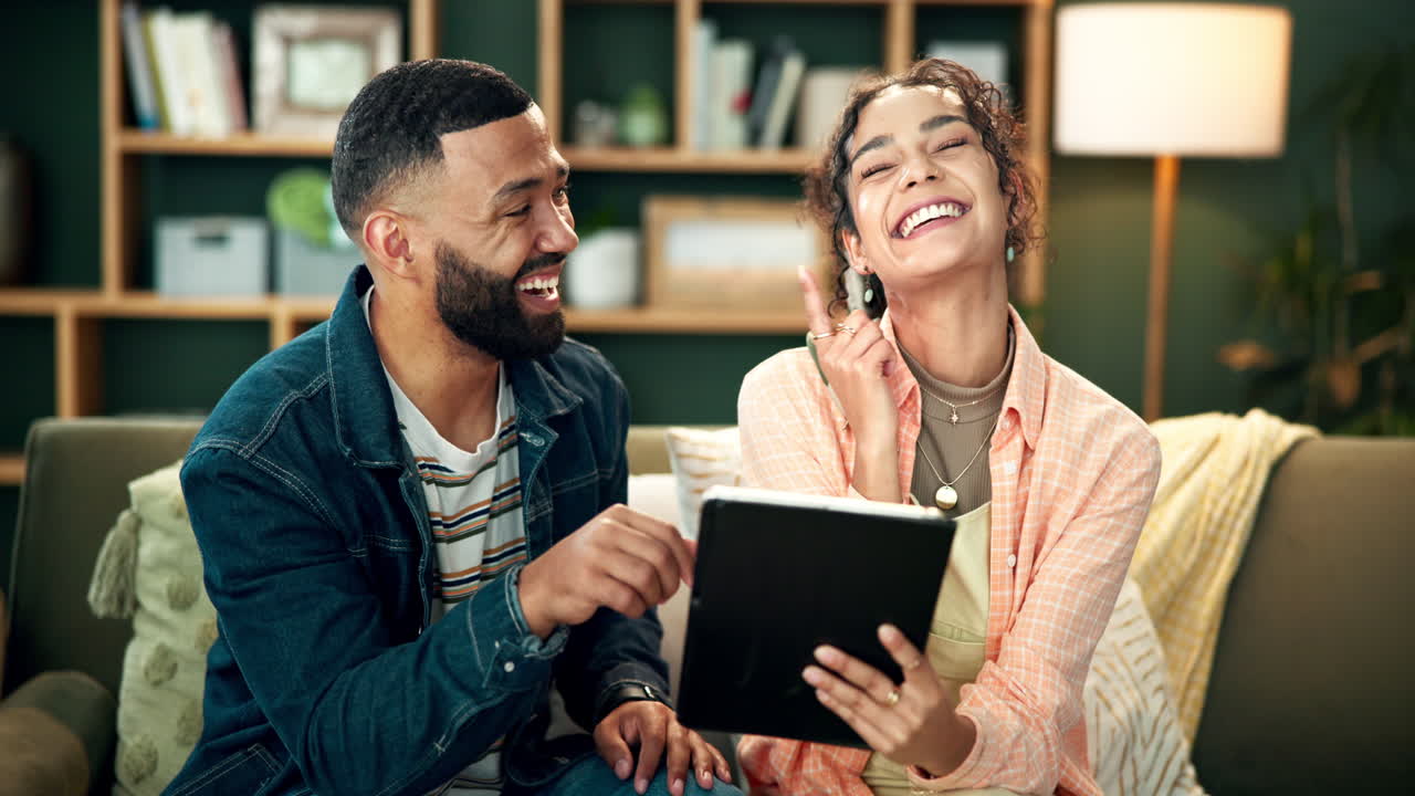 Couple laughing and sharing a loving moment with a tablet