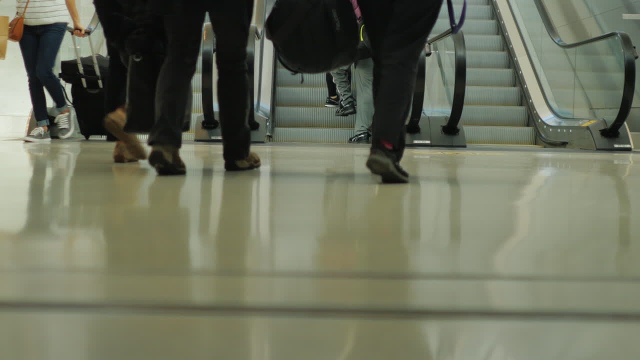 personas en una escalera mecánica del aeropuerto 1