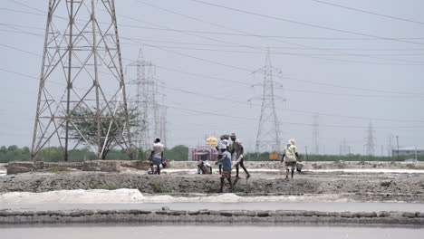 under the blazing heat of the midday sun, people work hard in the salt pan