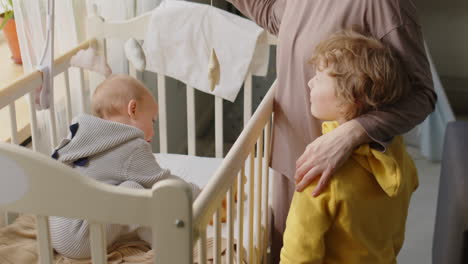 mother and little son talking by baby crib