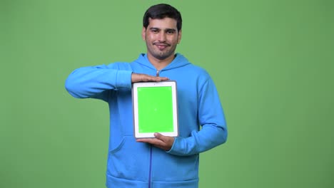joven persa guapo mostrando la tableta digital