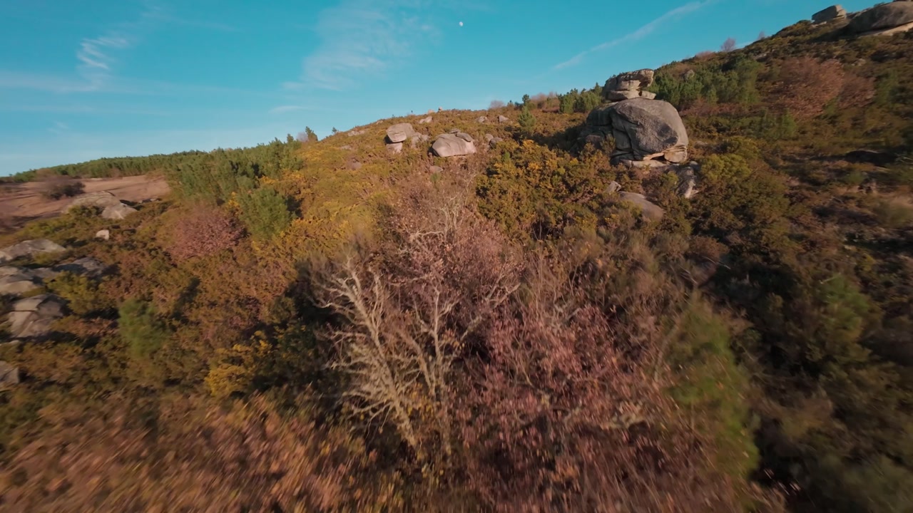 Aerial View Of Hill Covered In Green And Brown Vegetation And Big Boulders