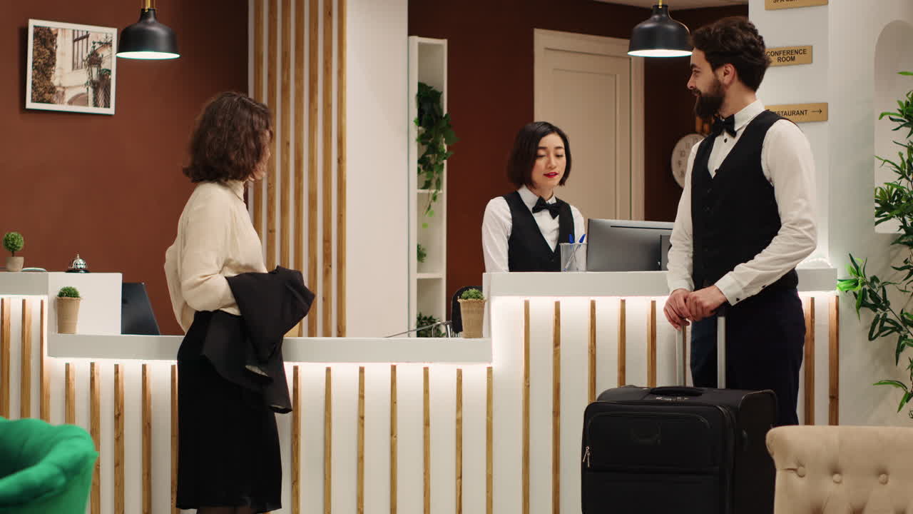 Guest helped by bellboy with luggage