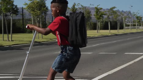 boy riding scooter and crossing the road