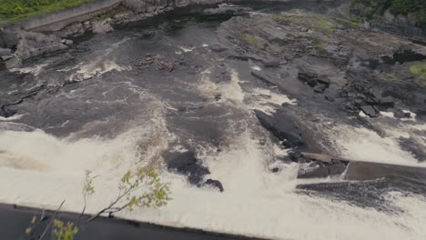 dam with water flowing rapid in sherbrooke, canada - aerial shot