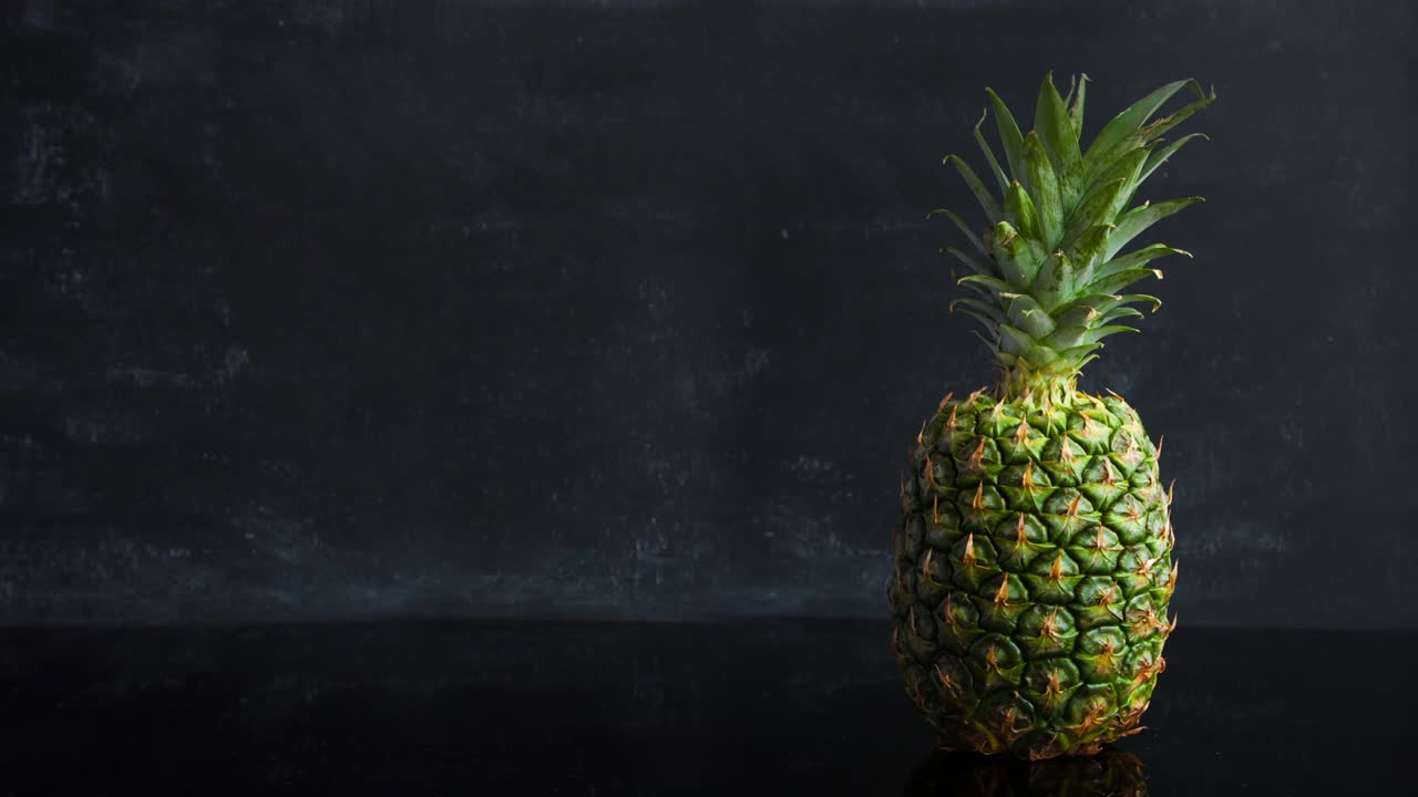 stop motion frutas tropicales maduras de piña sobre un fondo negro. imágenes de bucle de alimentos de lapso de tiempo