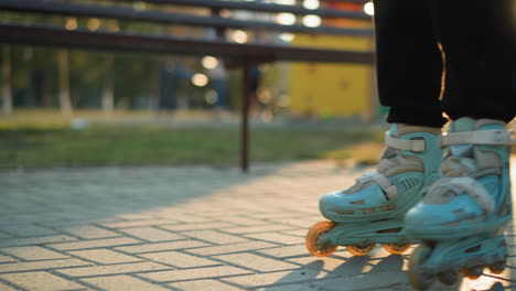 a close-up shot of a person s feet wearing rollerblades, gliding smoothly along a paved path in a park. the background is blurred, focusing attention on the rollerblades and the motion of skating