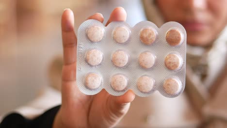 person holding a blister pack of pills