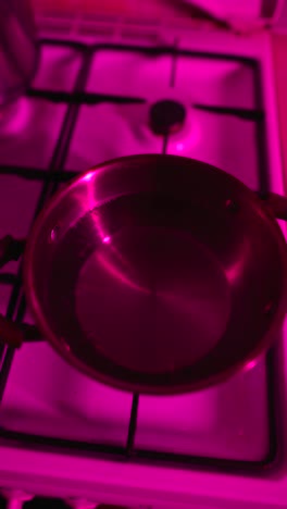 cooking on a gas stove with pink light