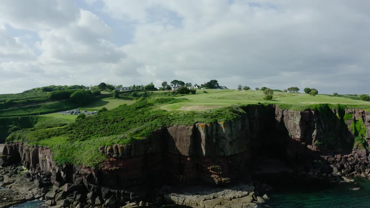 Orbiting drone shot of steep cliffs off of Ireland's coast.