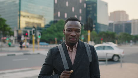 Retrato-De-Un-Joven-Afroamericano-Exitoso-Sonriendo-Confiado-En-Las-Calles-Urbanas-Disfrutando-Del-Estilo-De-Vida-Viajando-Al-Trabajo