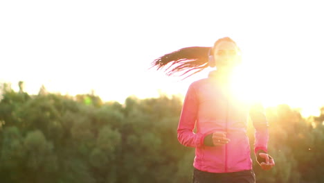 una carrera matutina en el parque cerca del estanque en los rayos soleados del amanecer, la niña se está preparando para mariano y llevar un estilo de vida saludable