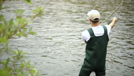 Toma-En-Cámara-Lenta-De-Un-Pescador-Caucásico-Lanzando-Su-Anzuelo-Mientras-Pesca-Con-Mosca-8