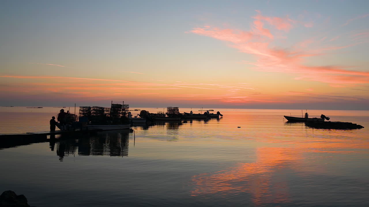 Silhouette fisherman pulling fish traps on wooden boats on water to the pier on colorful reflection twilight sunrise clouds sky over sea background, Bahrain