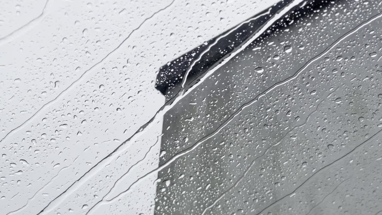 rain drops run down glass window skylight on a moody overcast day bad weather in england uk london