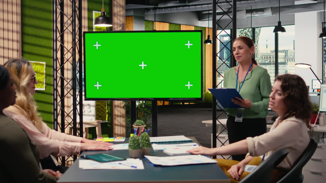 Female coworkers team use isolated TV monitor to support the business briefing