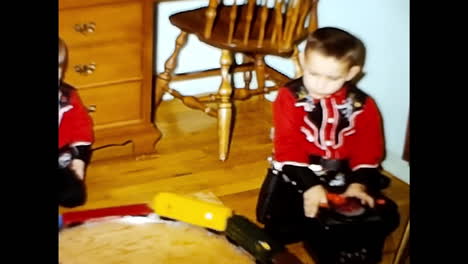 two toddlers playing with toys on the floor. circa usa - 1970s: two toddlers, in a 1970s video archive from the usa, are engaged in play as they interact with various toys on the floor.