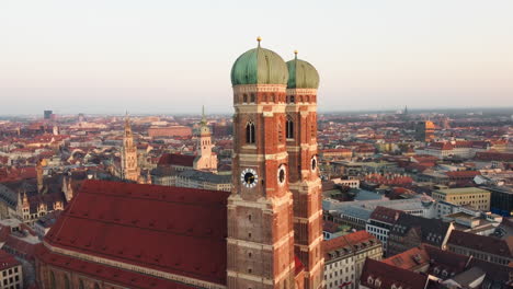 Toma-Aérea-En-órbita-De-La-Hermosa-Catedral-Histórica-Llamada-Frauenkirche-En-Munich-Al-Amanecer-Dorado