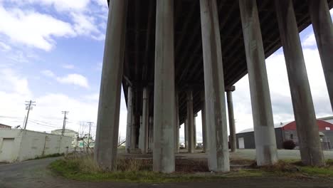 passing under a concrete overpass from left to right on a partly cloudy spring day after a brief rain