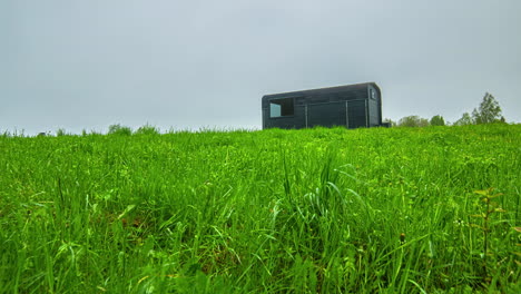 long-time-lapse-of-the-clouds-and-sun-over-a-camp-trailer-in-a-field-of-lush-wheat