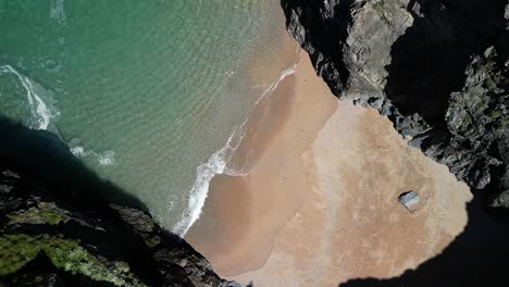 Cala-De-Cornwall-Con-Playa-Y-Acantilados-Rocosos-Desde-Una-Vista-Aérea-De-Arriba-Hacia-Abajo-En-Cámara-Lenta,-Reino-Unido