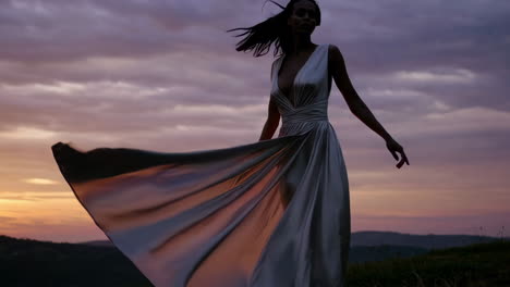 silhouette of a woman in a flowing dress at sunset