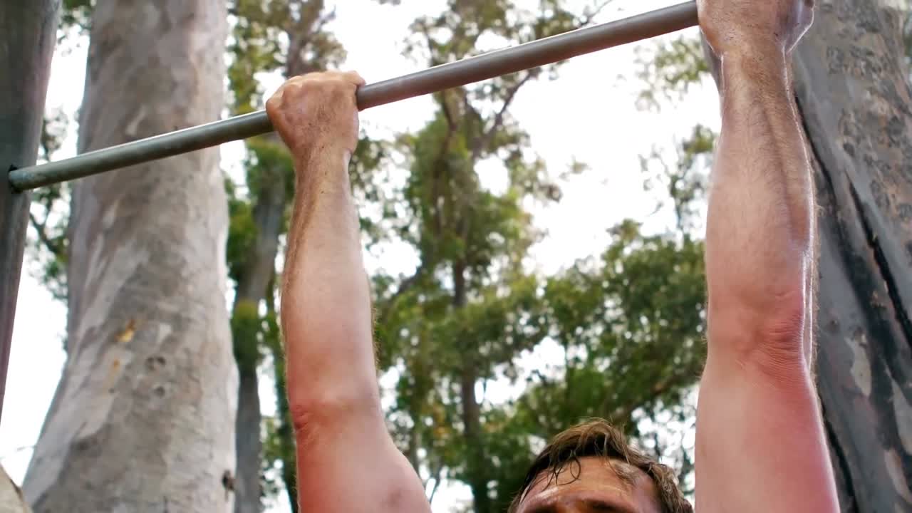 hombre realizando pull-ups en el campamento de entrenamiento