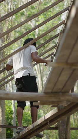 man working on a wooden roof structure