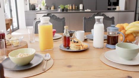 cerca de la mesa con comida y bebidas para el desayuno en la cocina, en cámara lenta