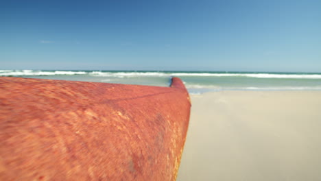 walking past large rusty orange pipe leading into ocean