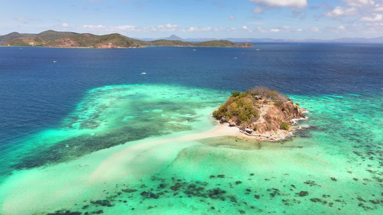 Aerial view of Bulog Dos Island, Philippines, featuring a scenic sandbar, clear turquoise waters, coral reefs, and nearby lush islets under a bright sunny sky in a tropical setting