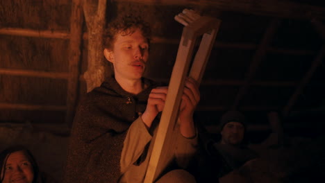 medieval craftsman working on a wooden instrument