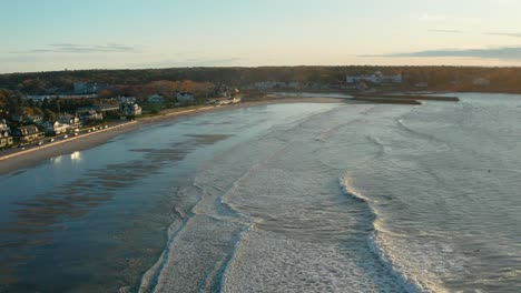 aerial of surf and homes at maine beach at dawn