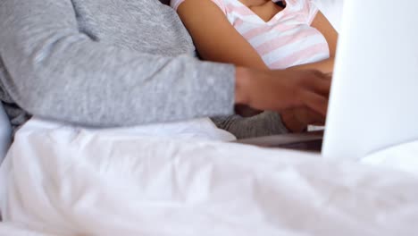 Couple-using-laptop-on-bed-in-bedroom-4k