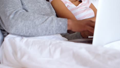 pareja usando computadora portátil en la cama en el dormitorio 4k