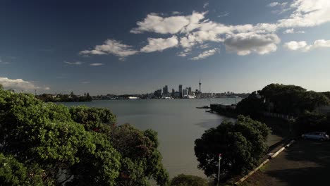 amazing drone crane reveal auckland, new zealand cityscape over lush green trees