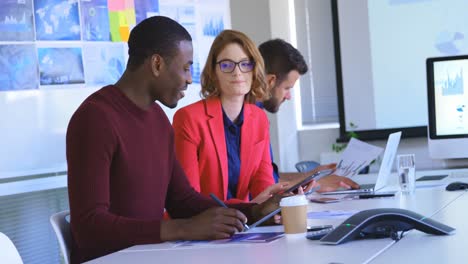 mixed race business colleagues discussing over digital tablet in modern office 4k