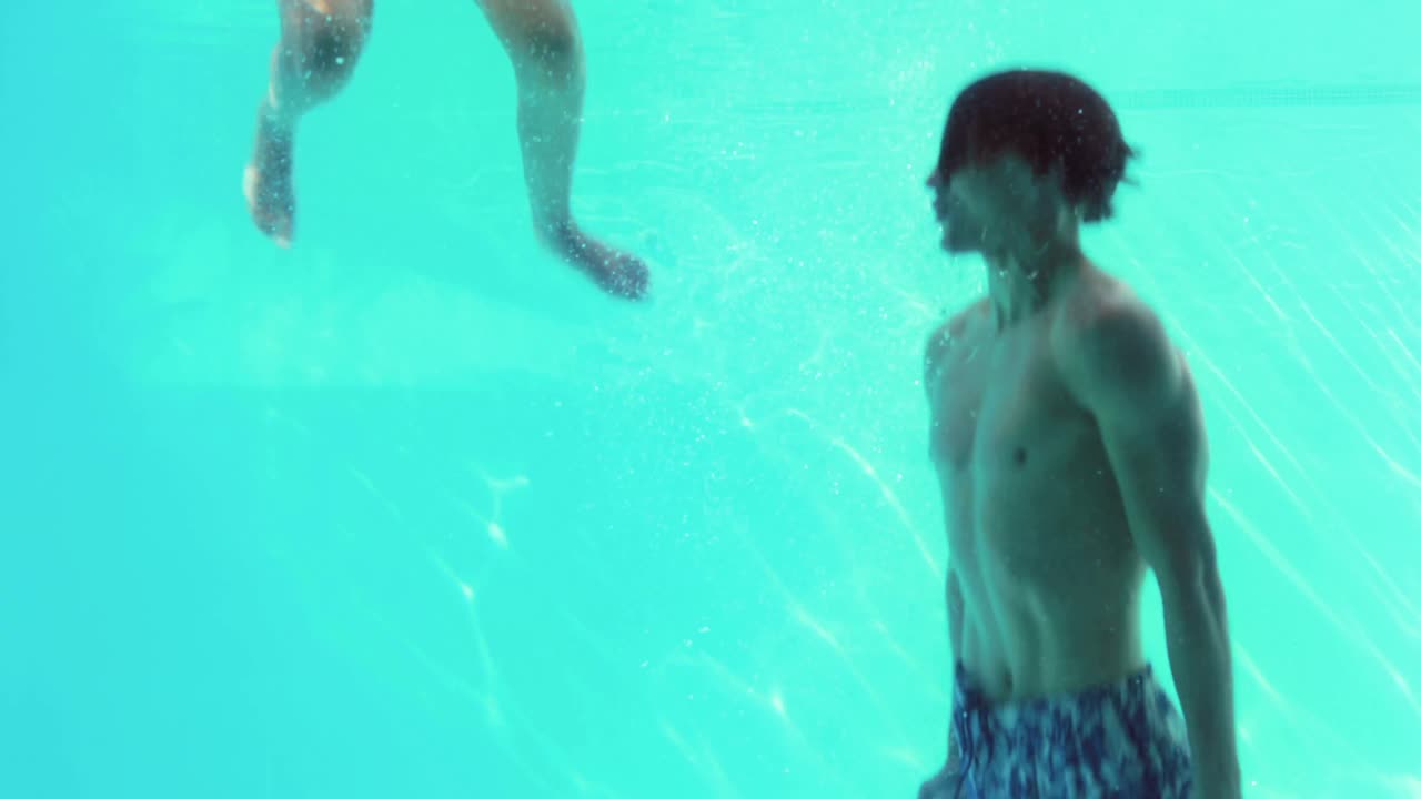 행복 한 커플 이 함께 수영장 에 뛰어들고 있다