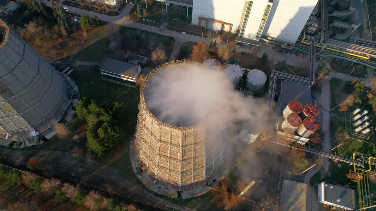 Aerial drone vertical view of thermal power plant in Chisinau, Moldova. View of pipes with felling steam, sunlight