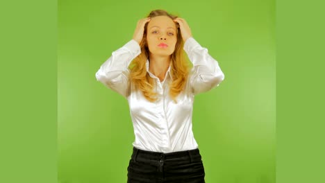 4k. mujer de negocios poniendo su cabello ante el espejo. aislada en un fondo verde. chromakey.