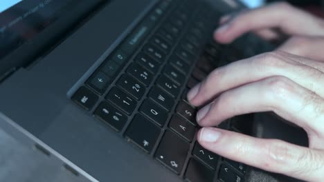 Close-up of man&#039;s hands swiftly typing on laptop keyboard