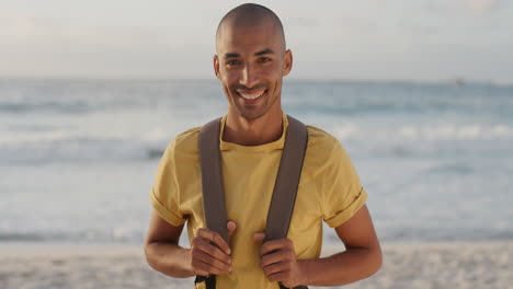 Retrato-De-Un-Joven-Feliz-En-La-Playa-Sonriendo-Mirando-La-Cámara-Disfrutando-De-Una-Cálida-Aventura-De-Vacaciones-De-Verano-En-La-Hermosa-Costa-Del-Océano