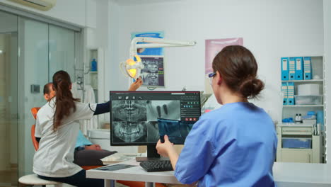 stomatologist nurse comparing radiographics looking at computer