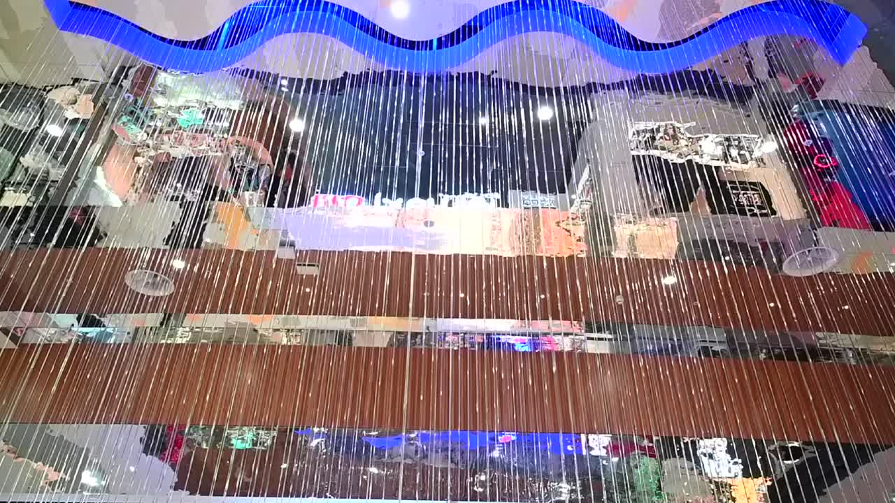 View of a hanging string light curtain installation beneath a wave shaped ceiling in Nicosia Mall, Cyprus