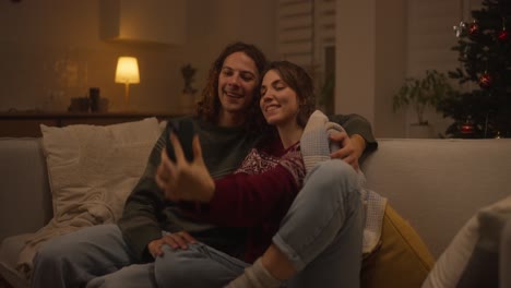 couple taking a selfie on the couch during the christmas season