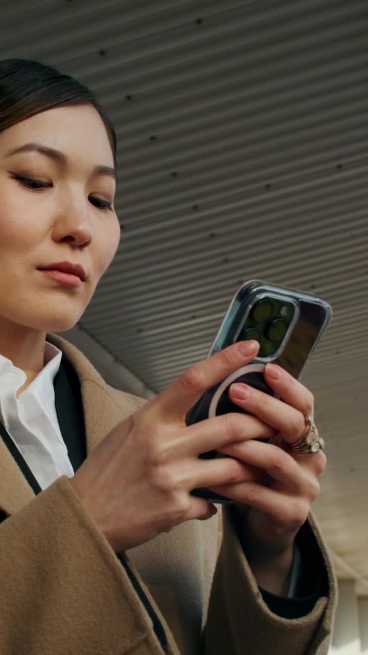 밖에서 스마트폰을 사용하는 여성