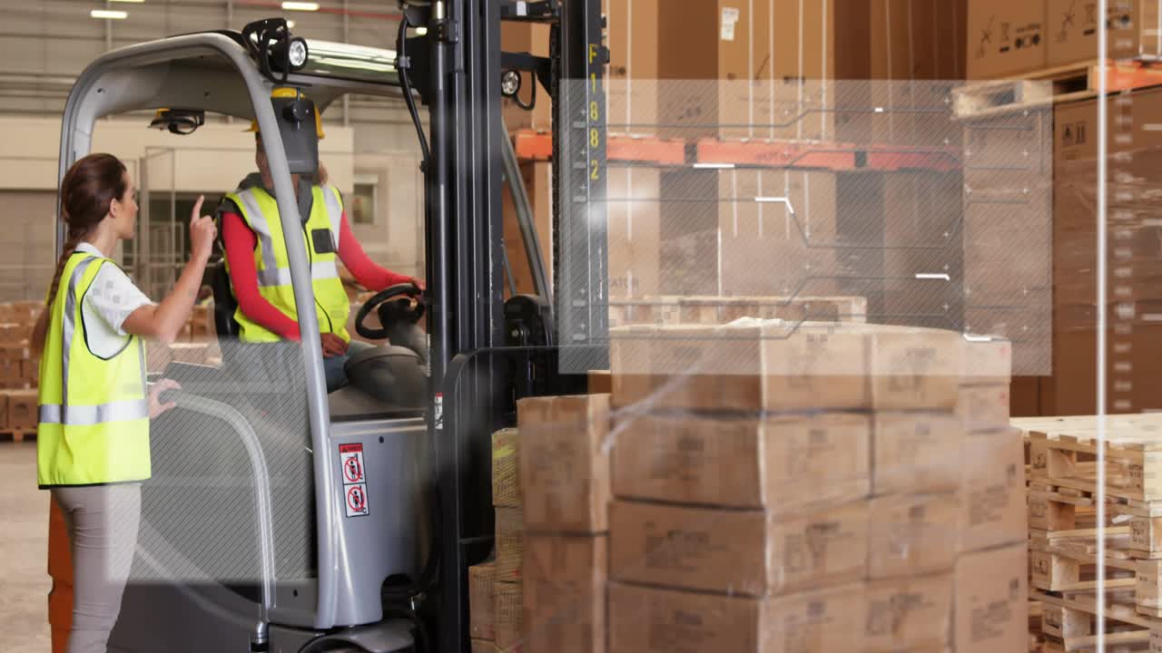 Warehouse operator driving forklift following guide gesturing and aligning pallet for safe storage
